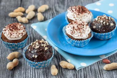 Gri ahşap arka planda çikolata ve fındıklı lezzetli çikolatalı kekler.