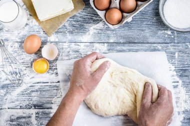 Hamur pişirme tarifi ekmeği, çörekler, pizza ya da turta pişirme malzemeleriyle çalışan eller mutfak masasının arka planında yatıyordu..