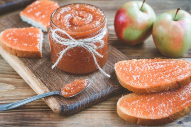 Elmalı elma reçeli, reçelli bir dilim ekmek ve ahşap zemindeki keten kumaşta reçel..