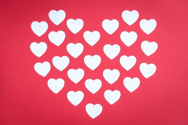 Kırmızı arka plandaki küçük beyaz kalplerin kalbi. Sevgililer Günü konsepti.