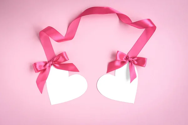 Две Белые Бумажные Валентинки Сердце Розовыми Лентами Лук Розовом Фоне — стоковое фото