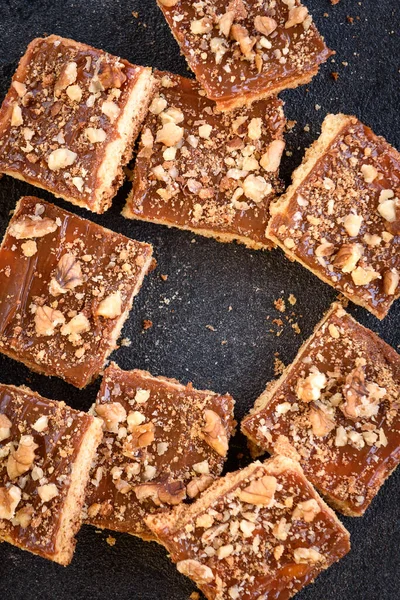 Galletas Caseras Caramelo Shortbread Cuadrados Con Nueces Sobre Fondo Negro — Foto de Stock