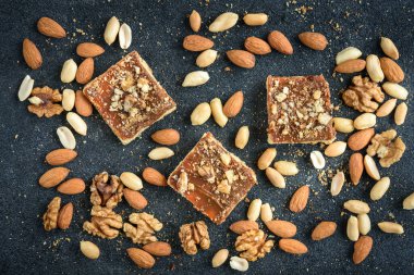 Ev yapımı karamelli kurabiyeler fındıklı kurabiyeler siyah arka planda kırıntıları olan kare şeklinde yerleştirilmiş..