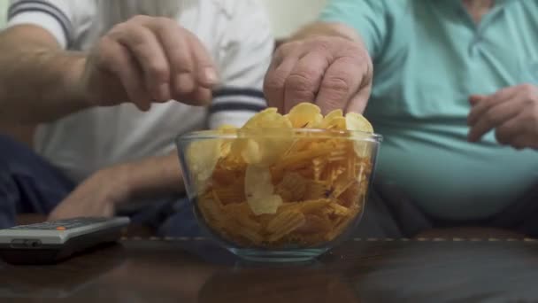 Gordura Homens Comer Chips Enquanto Assiste — Vídeo de Stock