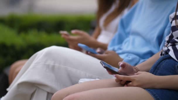 Unga Kvinnor Parken Sitter Smartphones — Stockvideo