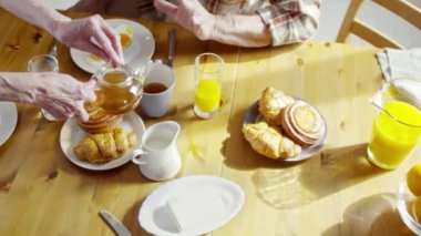 Aile kahvaltısını masada yapıyor.