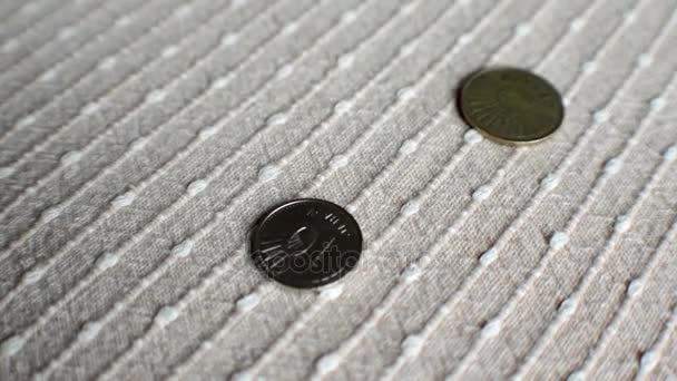 Монеты падают и отскакивают на текстурированную поверхность — стоковое видео