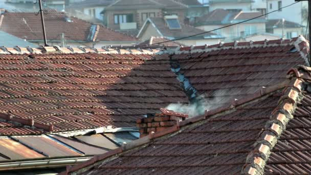 Kouř vycházející z komína na střeše domu 