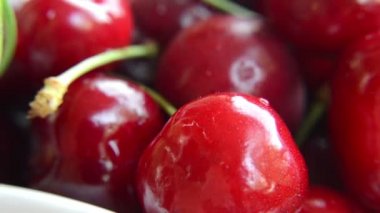 Beyaz zemin üzerinde dönen olgun kırmızı kirazların yakın çekim görüntüsü 