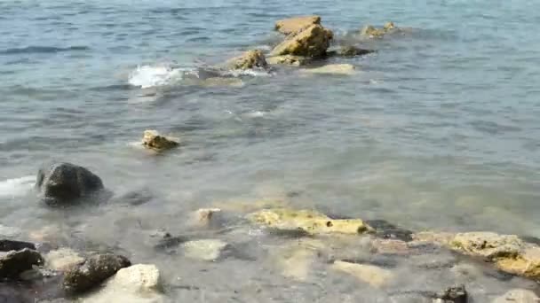 Закрыть небольшие волны над скалами на берегу белого песчаного пляжа — стоковое видео
