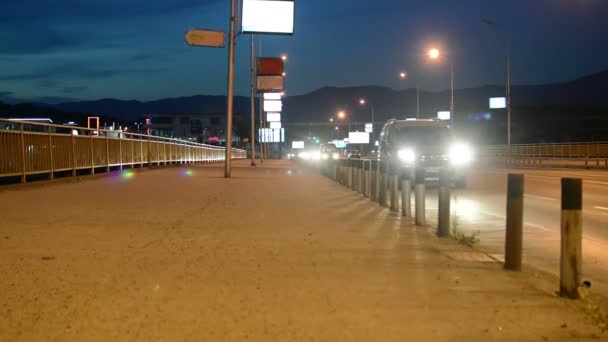 Auta v noci na cestách přes most do města — Stock video