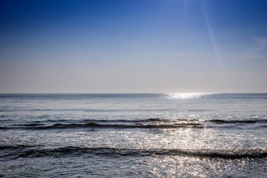 Sabah mavi gökyüzünün altında sakin deniz manzarası 