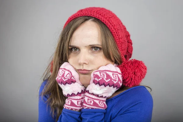 若い女性寒いから暖かい 揺れと震え 身に着けているを維持しようと灰色の背景上の手袋と帽子のニット — ストック写真