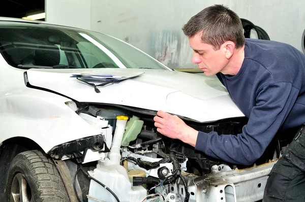Mechanic inspecting car body damage at auto repair shop service — Stock Photo, Image