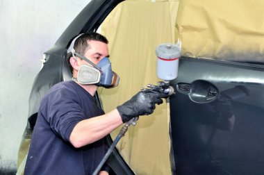 Profesyonel araba ressam siyah bir araç çalışma.
