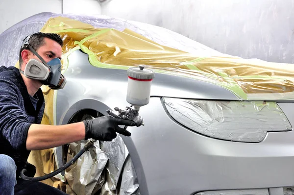 Handsome worker painting a car. No model real mechanic. — Stock Photo, Image