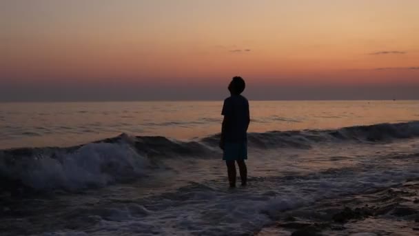 Силует сумної пригніченої людини на пляжі під час заходу сонця — стокове відео