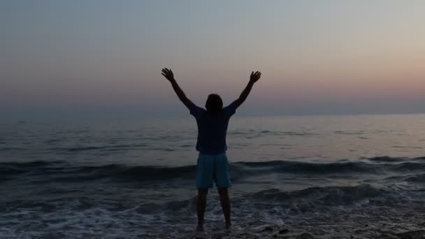 Silhueta de triste homem deprimido na praia durante o pôr do sol — Vídeo de Stock