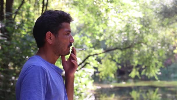 Homem fumando uma floresta de cigarro — Vídeo de Stock