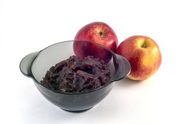 Siyah şeffaf bir tabakta elma reçeli ve beyaz arkaplanda elmalar