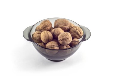 Beyaz arka planda siyah şeffaf bir tabakta ceviz