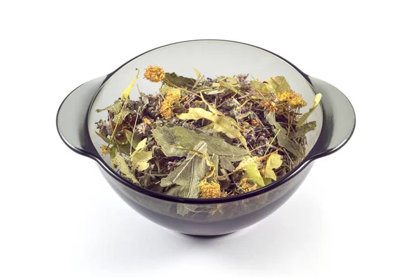 Beyaz arka planda siyah şeffaf bir tabakta kurutulmuş şifalı bitkilerin karışımı.