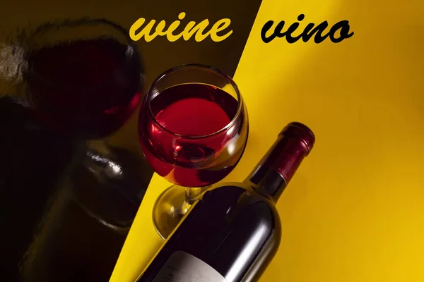 Sarı Zemin Üzerinde Bir Şişe Kırmızı Şarap Ngilizce Spanyolca Yansımaları — Stok fotoğraf