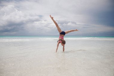 Çocuklar kumsalda oynarken eğleniyor.