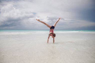 Çocuklar kumsalda oynarken eğleniyor.