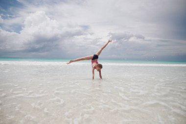 Çocuklar kumsalda oynarken eğleniyor.
