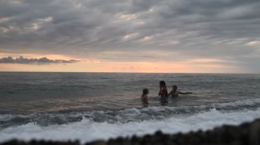 Çocuklar denizde yüzer.