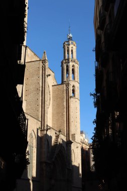 Santa Maria del Mar Kilisesi 'nin kulesi Çek manzaralı, Barselona, Katalonya, İspanya' da karanlık bir sokak.