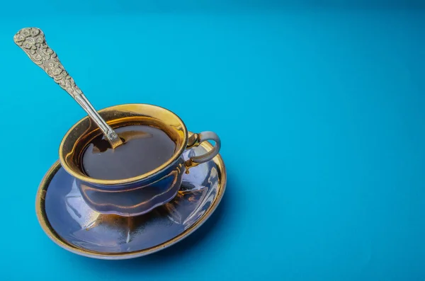 Coffee in a blue cup on a saucer on a blue background. Mock-up