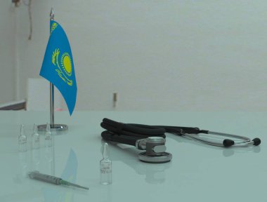 Şırınga, COVID 19 koronovirüs aşısı ve fonendoskop Kazakistan 'daki bir sağlık masasında..