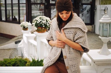 Açık moda şapka ve hırka giymiş genç bir kadın portresi