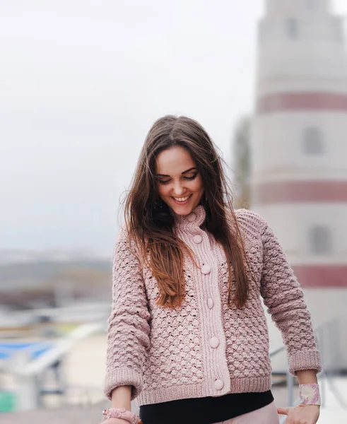 Aşağı bakıyor ve gülümsüyor, genç mutlu kadın portre sevimli yumuşak pembe kazak, sonbahar moda giyinmiş — Stok fotoğraf