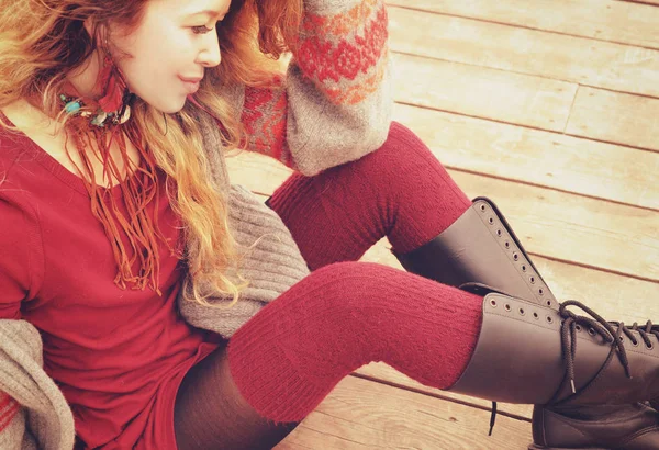 Молода тонка жінка модель, одягнена в теплі в'язані панчохи і черевики на колінах, ручна робота намисто , — стокове фото