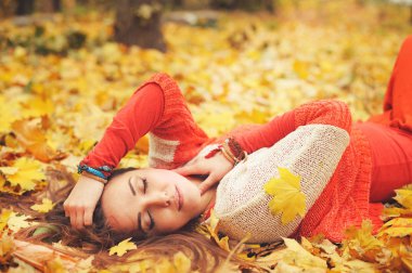 Mutlu dinlenme kız portre, park, akçaağaç yaprakları sonbaharda yalan gözler, moda Kazak giymiş kapalı