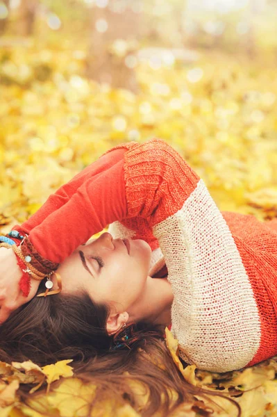 Спокійний розслаблений портрет жінки, відпочиньте, лежачи в осінньому листі в парку, закриті очі — стокове фото