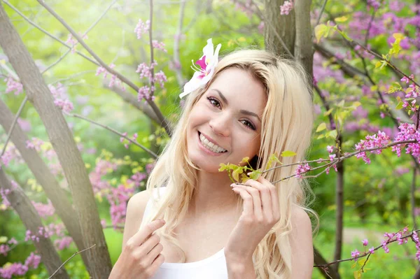 Retrato de belleza de mujer rubia sonriente, piel fresca perfecta y sonrisa blanca saludable, maquillaje básico diario, cabello largo con flor de orquídea —  Fotos de Stock