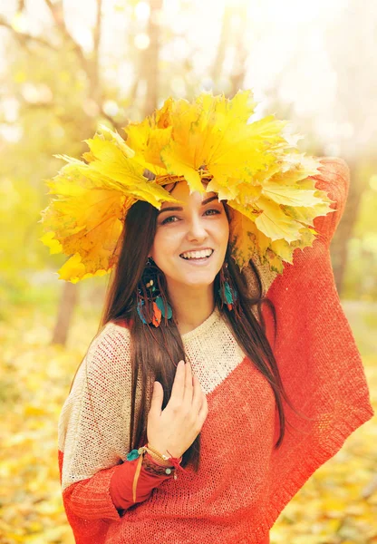 Mulher sorridente bonita com grinalda de folhas de bordo em uma cabeça — Fotografia de Stock