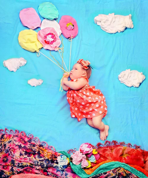 Младенец девочка летит на гелиевых шарах — стоковое фото
