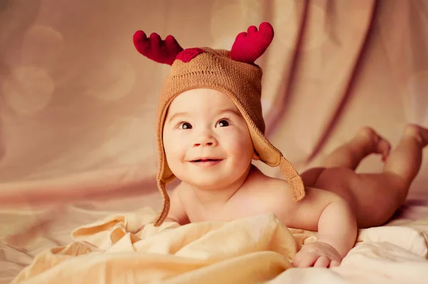 Leende baby klädd i jul rådjur hatt — Stockfoto