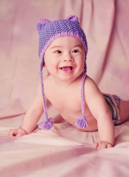 Retrato de un hermoso bebé de 6 meses sonriendo vestido con sombrero de punto divertido — Foto de Stock