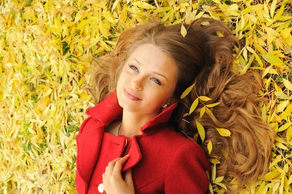 Close up pretty woman portrait lying on yellow maple leaves — Stock Photo, Image