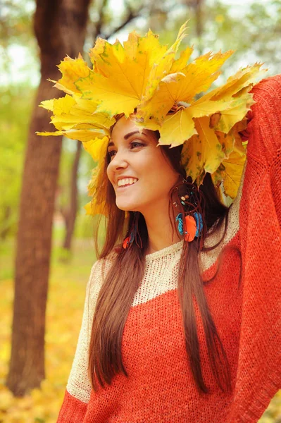 Young smiling woman with wreath of maple leaves on a head, outdoor portrait — Stock Photo, Image