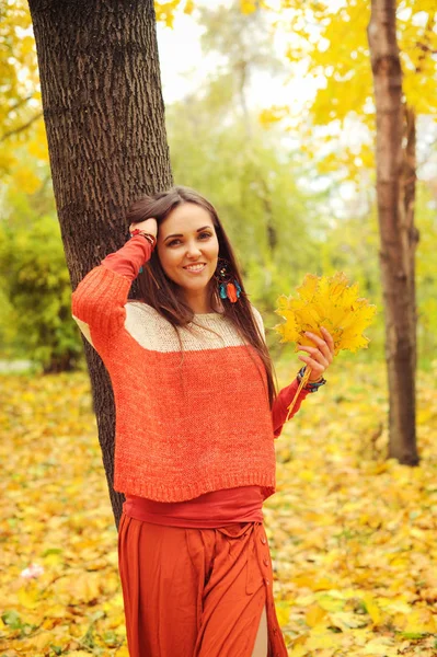 Pěkně usmívající se žena portrét, chůze v podzimním parku, oblečený v neformálním oranžový svetr a sukně — Stock fotografie