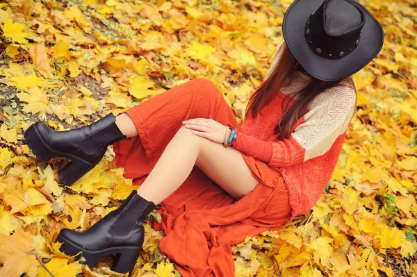 Hübsche junge Frau posiert im Herbst Park, Lederhut — Stockfoto