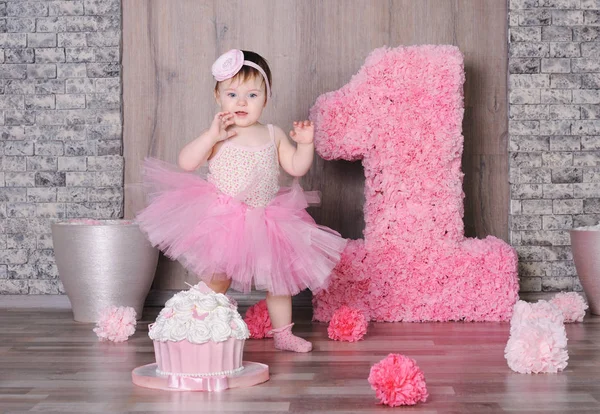 Leuke glimlachende babymeisje in roze jurk — Stockfoto