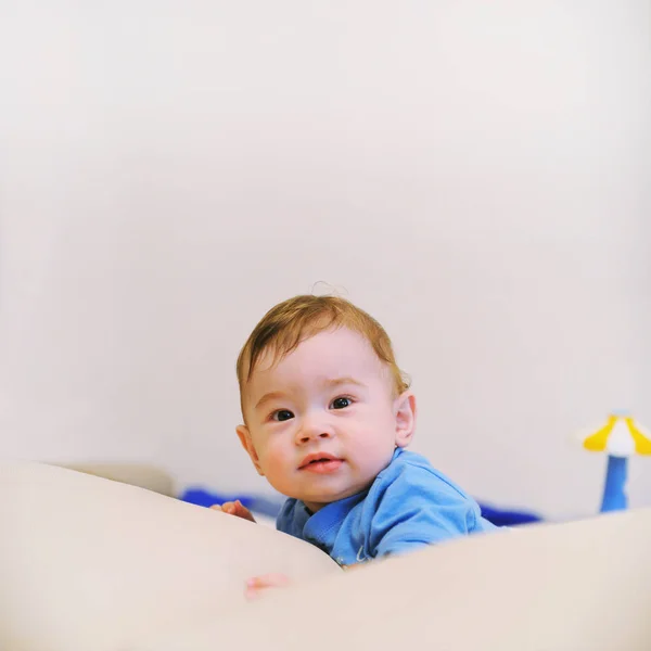 Mooie happy baby jongen liggen op een buik — Stockfoto